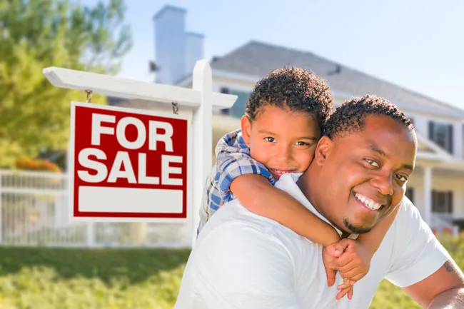 Father and son in front of home purchased with the legal help of an Edmonton real estate lawyer in the law firm Coley Hennessy Cassis